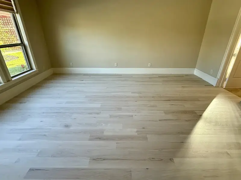 Light wide plank hardwood floor in an empty living room