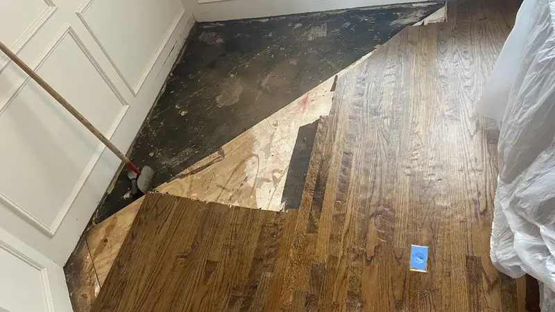 Damaged hardwood boards removed for repair, with new boards woven in